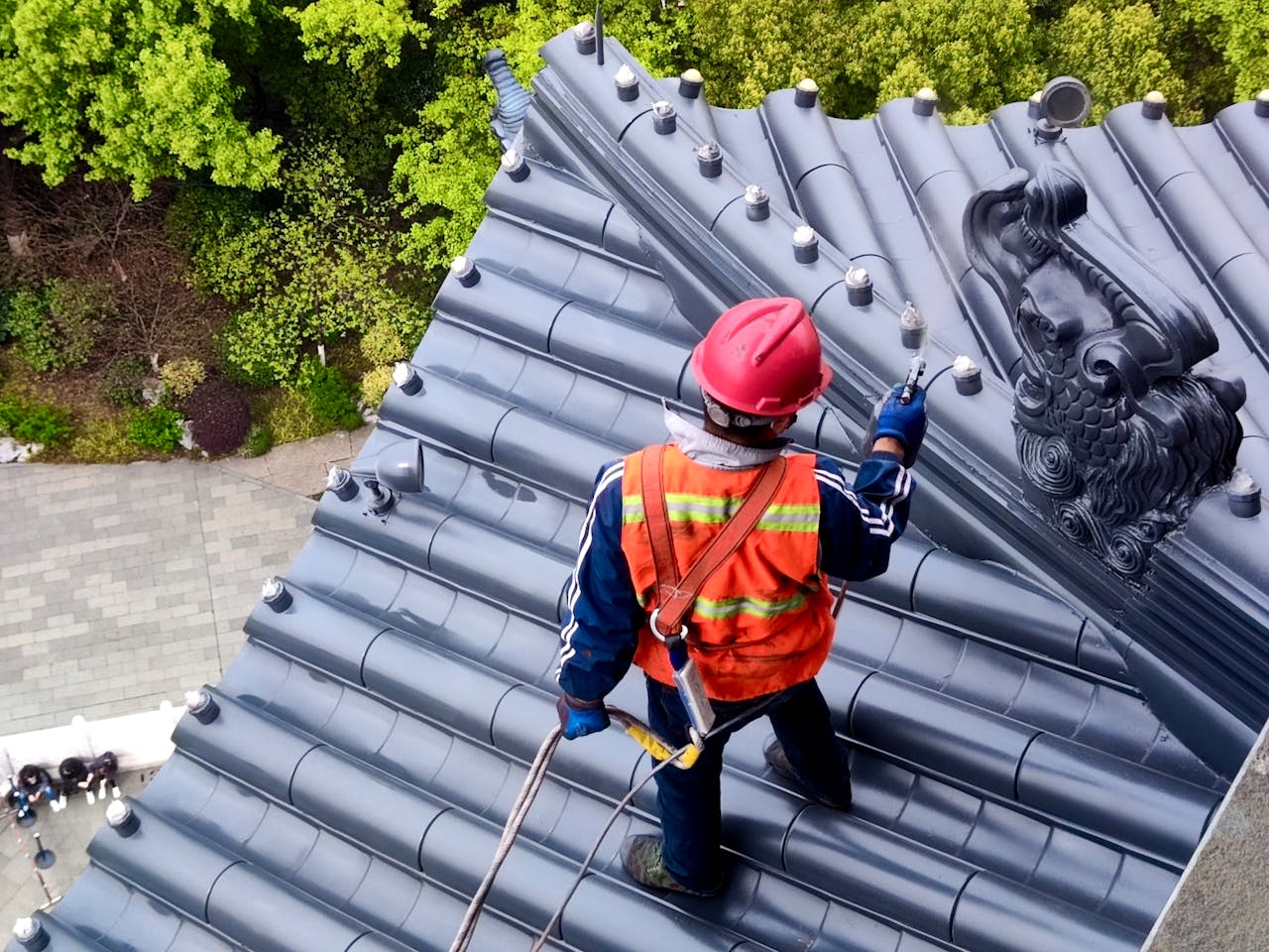 Mastering the First Impression: Your intriguing post title goes here Roof worker in Hangzhou, China, uses safety gear while maintaining traditional temple roof.